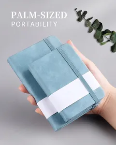 Detail of light blue pocket notebooks with textured covers and elastic bands