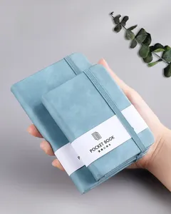 Detail of light blue pocket notebooks with textured covers and elastic bands