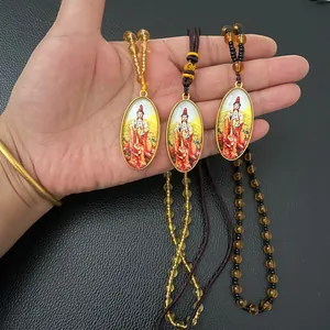 Detail of oval Guanyin Buddha pendants with golden metal frames and colorful beads