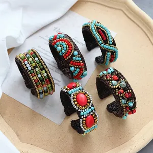 Detailed view of handmade bohemian cuff bracelets with colorful ethnic beads and stones