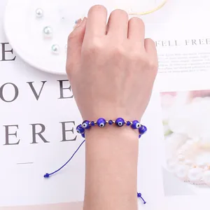Close-up of handmade blue Evil Eye beaded bracelet with adjustable cord on model wrist