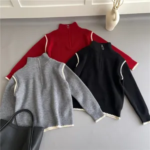 Detailed close-up of ribbed sweaters with half-zip collars and white wavy stitching