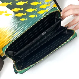 Detail of the green leather wallet interior featuring card slots and golden zipper