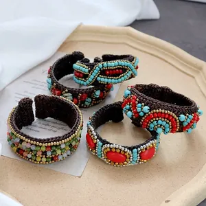 Detail of bohemian handmade woven bracelets with turquoise beads on a ceramic tray