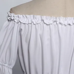 Close-up of white off-the-shoulder top with ruffled neckline and elastic cuff details