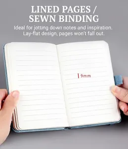 Detail view of small blue portable notebook showing 9mm ruled pages and sewn binding