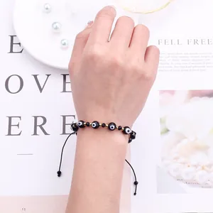 Close-up of handmade Evil Eye beaded bracelet with adjustable woven black cord on wrist