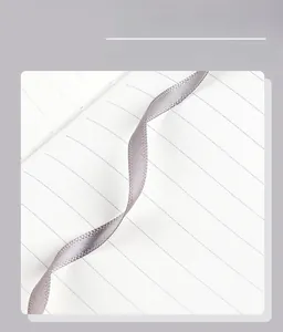 Detail view of the elegant silver silk ribbon bookmark on lined notebook paper