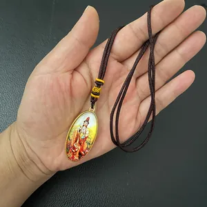 Detailed view of an oval Guanyin pendant with colorful religious art and gold frame