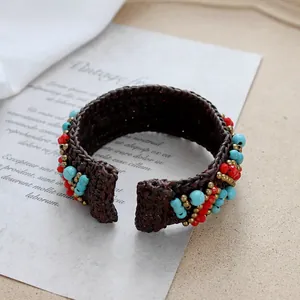Detail of bohemian hand-woven bracelet with turquoise beads and metallic accents