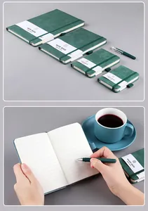 Detail of dark green leather notebooks with elastic bands and matching pens in various sizes