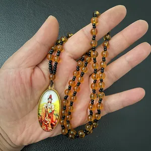 Close-up of golden framed oval pendant with colorful Guanyin Bodhisattva painting