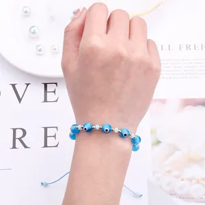Detail of adjustable blue evil eye beaded bracelet with handmade woven cord and gold spacers