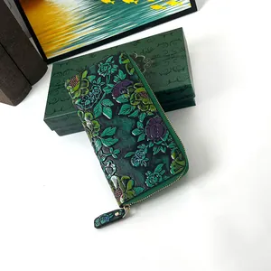 Detail of dark green vintage long wallet with exquisite embossed floral patterns and gold zipper