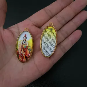 Macro detail of oval Buddhist amulet featuring Avalokitesvara icon and Great Compassion Mantra