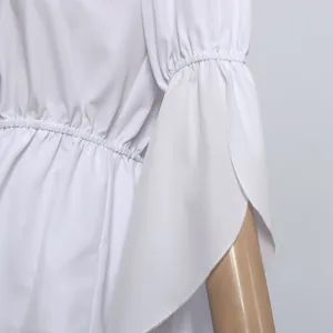 Detail of white off-shoulder top showing elastic smocked waist and flared ruffle sleeves