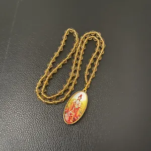 Oval Buddhist pendant necklace with amber beads and golden deity charm