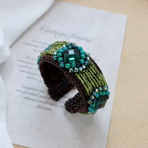 Detailed macro shot of handmade bohemian woven bracelet with green square stones