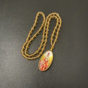 Detail of beaded necklace with oval gold-rimmed pendant featuring religious saint portrait