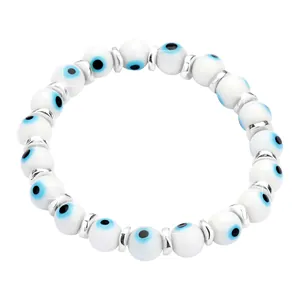 Close-up of white Evil Eye beaded bracelet with silver spacers on white background
