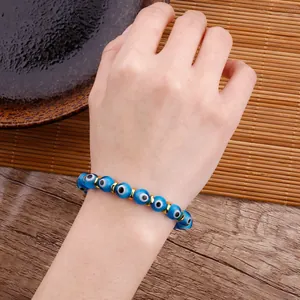 Close-up of handmade evil eye beaded bracelet with blue glass beads on the wrist