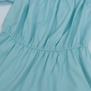 Detail view of the smocked elastic waist on this light blue off-shoulder summer top