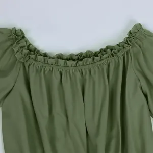 Detail of ruffled off-shoulder neckline with elastic smocking on green summer top