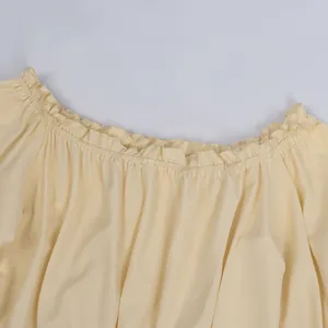 Detail of ruffled elastic neckline on a pastel yellow summer top for women