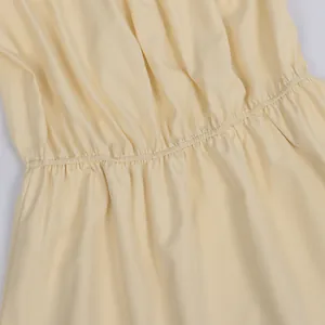 Close-up of shirred elastic waist detail on a pale yellow off-shoulder summer blouse