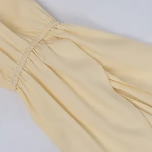 Detail of elastic smocking design and neat overlock stitching on cream summer top fabric
