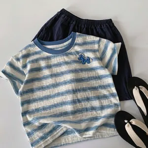 Detail of blue and white striped cotton T-shirt with horse embroidery and navy shorts