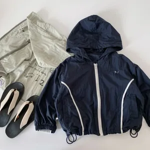 Detail of navy blue kids waterproof down jacket with contrast white zipper and drawstrings