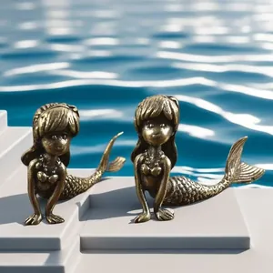 Detail view of two antique bronze mermaid figurines with intricate scale textures