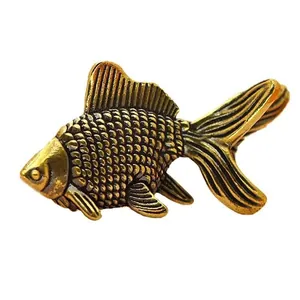 Macro shot of antique brass goldfish figurine with detailed scales and dynamic fins