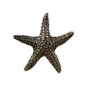 Macro detail of antique brass starfish ornament with realistic textured grain finish