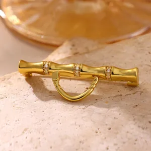 Close-up of golden bamboo brooch with micro-pave zircons on natural stone
