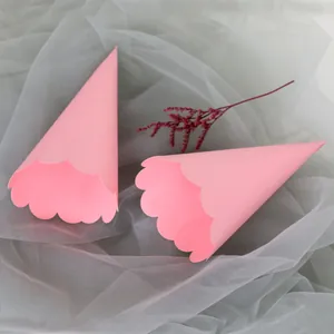 Close-up of pink wave-edged paper wedding cones on a soft mesh background decoration