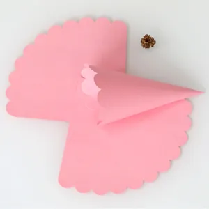 Close-up of pink wave-edged paper rolled into a DIY cone for wedding celebrations