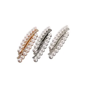 Detail of three metal hair clips with double rows of pearls and sparkling rhinestones