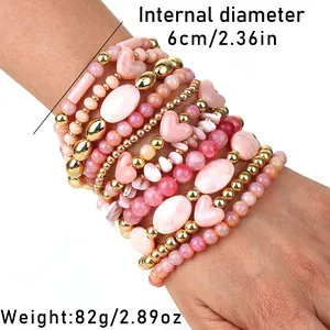 Set di 11 braccialetti di perline rosa fatti a mano con cuore indossati su modella