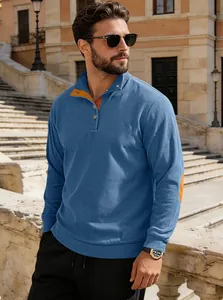 Détail du sweat-shirt bleu gaufré avec coudières orange contrastées et col polo boutonné