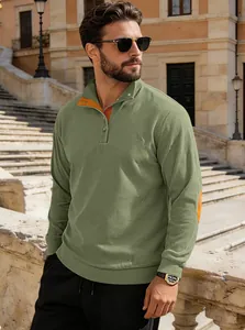 Détail d'un sweat en velours vert avec col contrasté orange et fermeture boutonnée