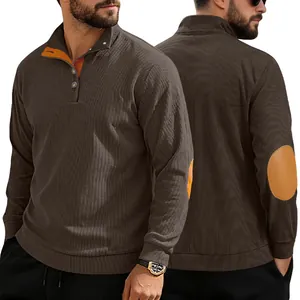 Détail d'un sweat en velours côtelé marron avec patchs orange aux coudes et col à boutons