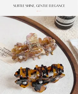 Macro detail of acetate clover hair claws with floral patterns and pearl center accents