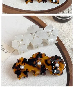 Detail of floral hair claws in pearly white and tortoiseshell with pearl centers