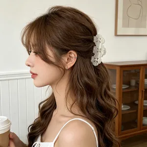 Elegant white acetate clover hair claw clip with pearl center on female model