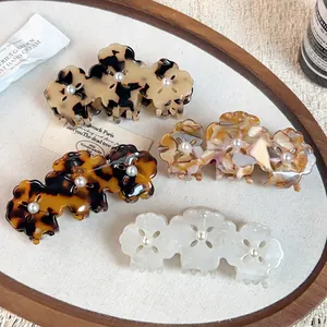 Chic clover acetate hair claws set in leopard, tortoiseshell, and pearl finishes