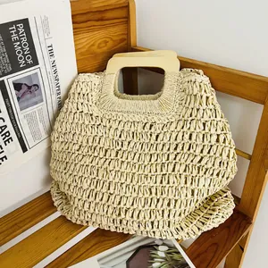 Detailansicht der gewebten Strohstruktur und Holzgriff an der Sommer-Strandtasche