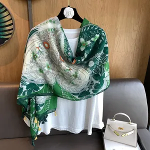 Détail de l'écharpe à fleurs vert forêt et beige avec anneaux orange et glands jaunes