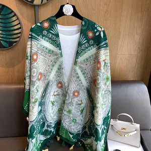 Détail d'une écharpe bohème à fleurs avec motifs mandala verts et finitions franges